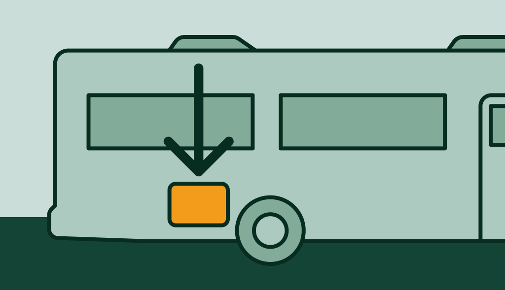RV with a downward arrow pointing to an orange compartment, indicating the location of the water heater.
